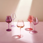 Set of colorful wine glasses on a light surface with a neutral background