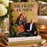 Book titled 'Hilfiger Homes' on a table with decorative items.