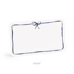 White pillow with a blue border and bow on a white background