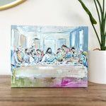 Decorative box with artistic design on a wooden surface with a plant in the background