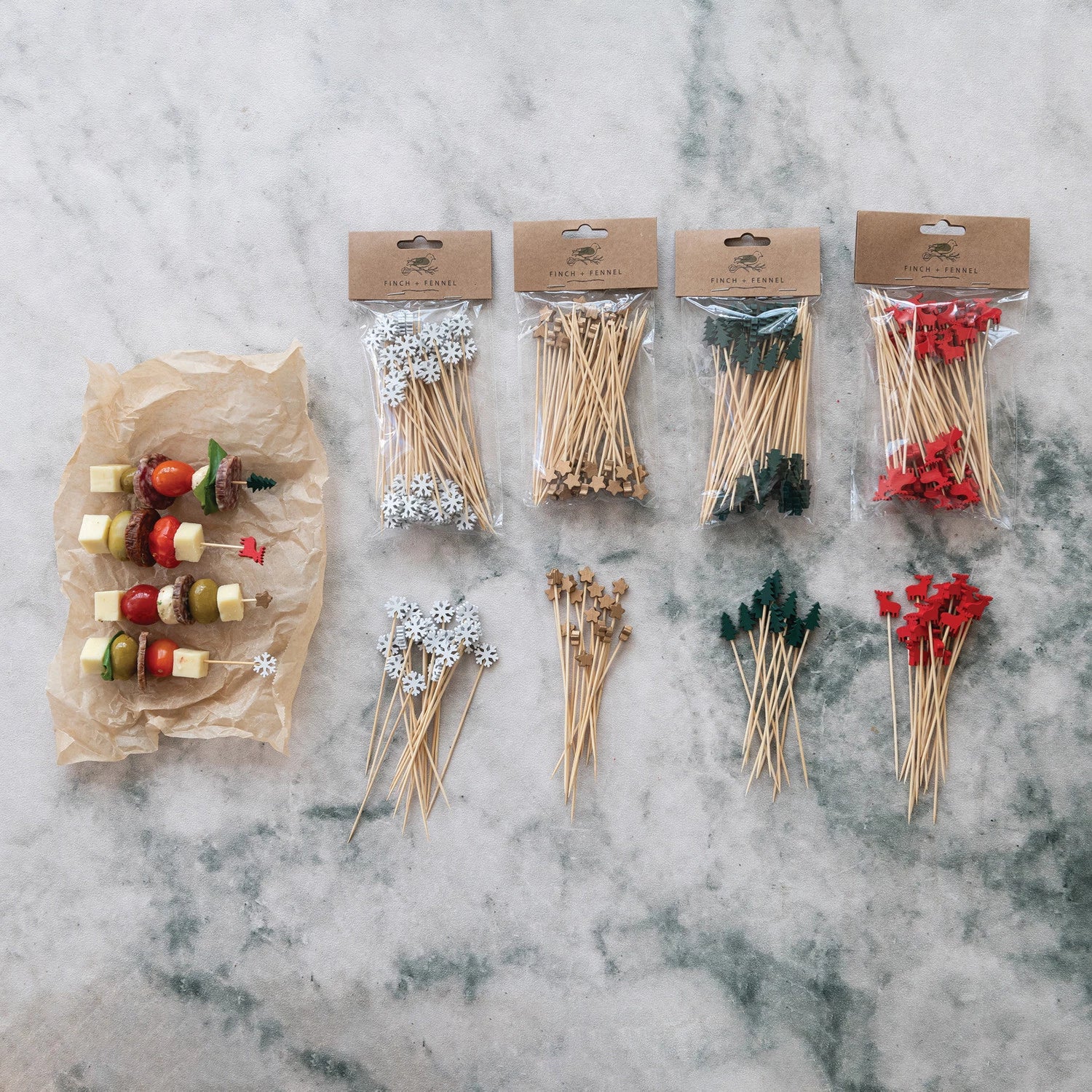 Assorted wooden skewers and toothpicks in packaging on a marble surface