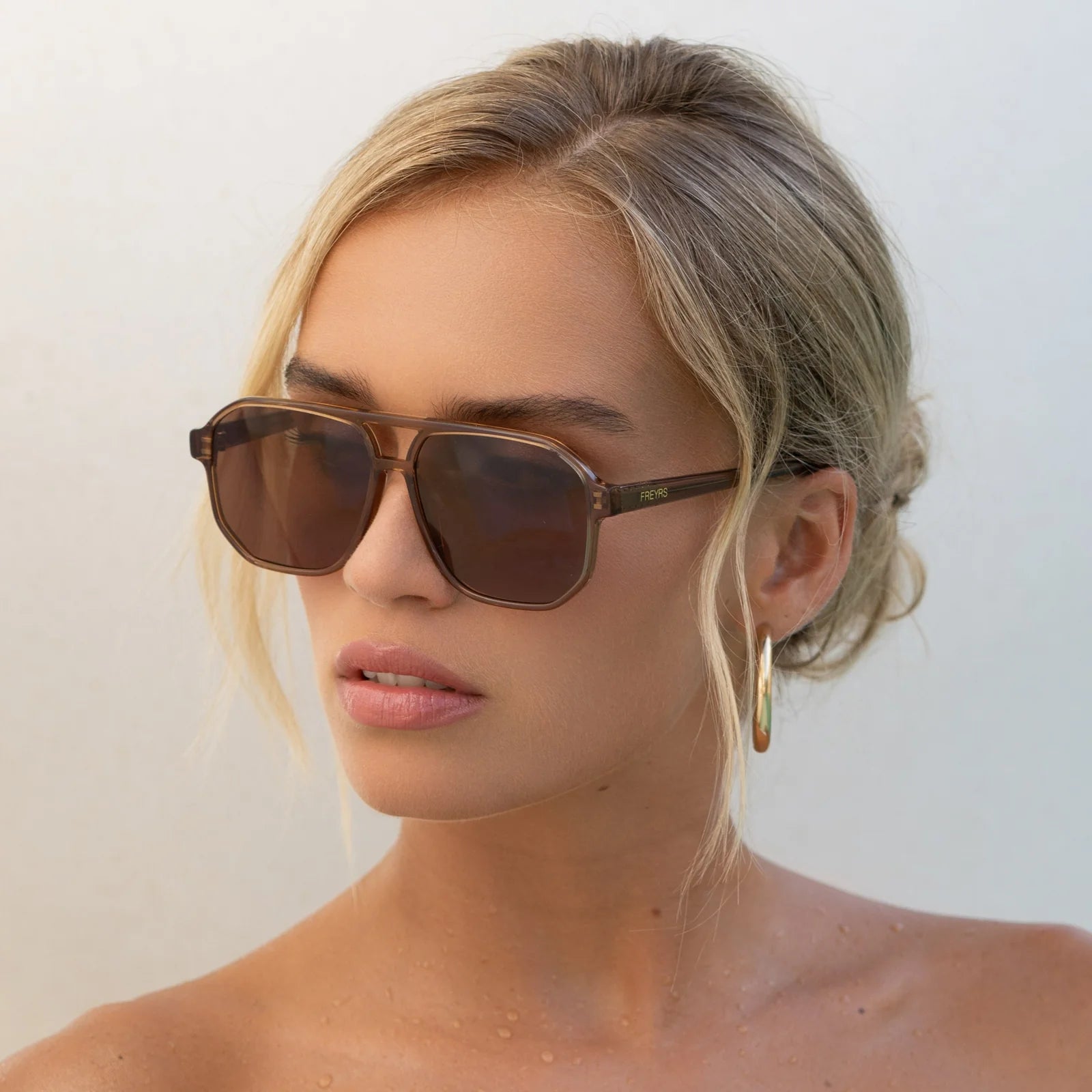 Woman wearing sunglasses with a plain background