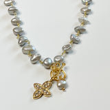 gold chain with intermittent organic gray stones, front. toggle closure with floral charm