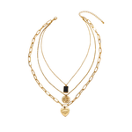Three-layer gold necklace featuring a black rectangular pendant, a coin medallion, and an engraved heart charm, all connected by one clasp, displayed on a white background.