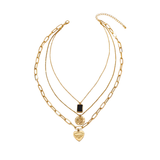 Three-layer gold necklace featuring a black rectangular pendant, a coin medallion, and an engraved heart charm, all connected by one clasp, displayed on a white background.