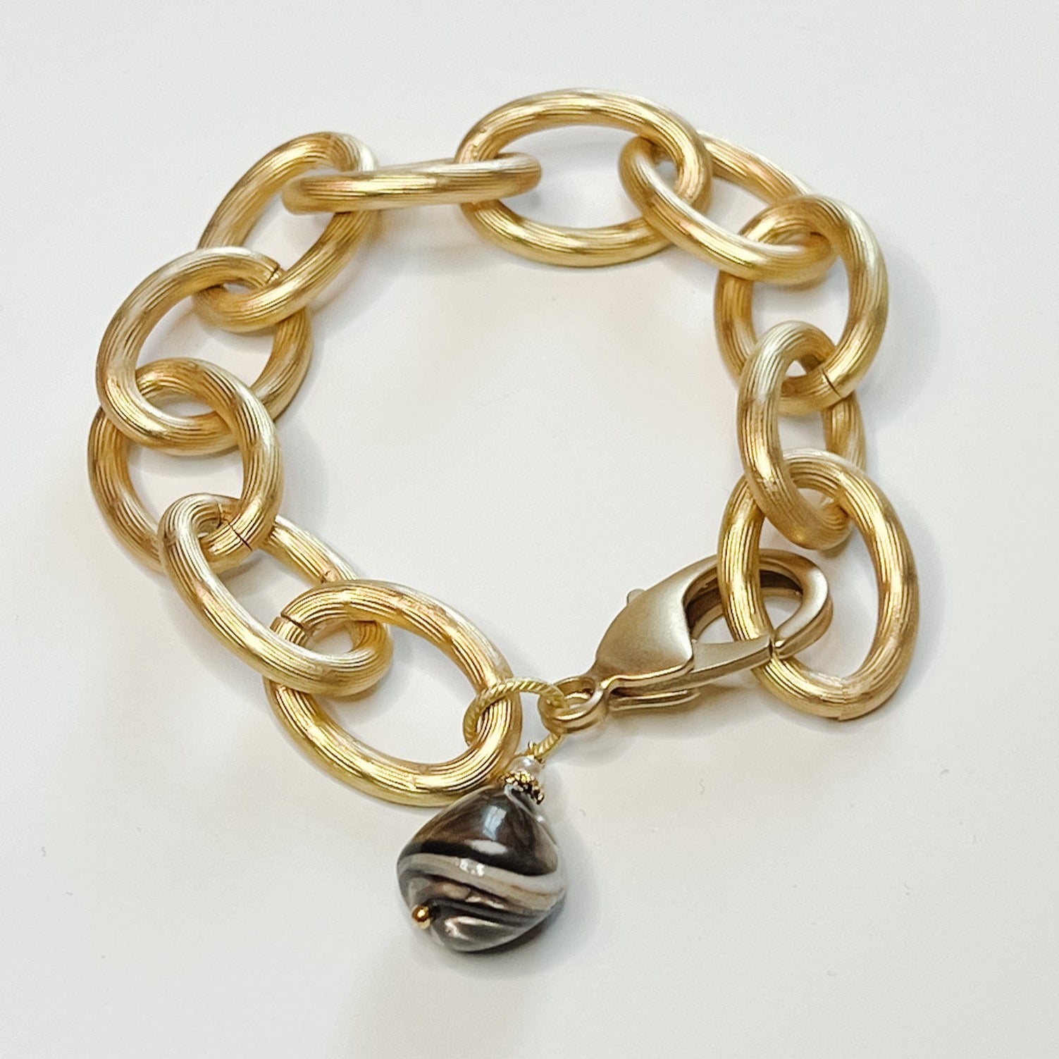 chunky gold bracelet with brown charm