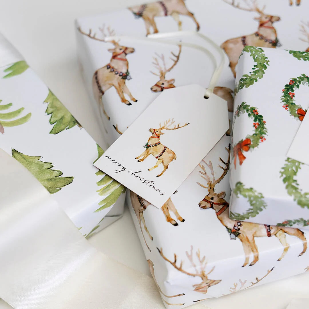 Christmas-themed gift wrap with reindeer and wreath designs on a white background.