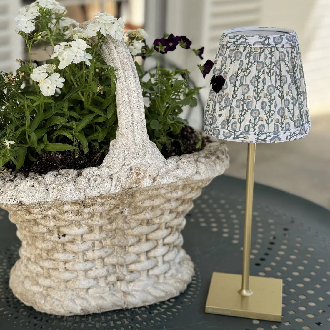 decorative concrete basket with white flowers with a rechargeable lamp with a floral shade