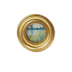 Decorative circular art magnet with a gold frame on a white background