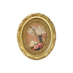 Decorative oval framed art magnet with floral painting inside on a white background