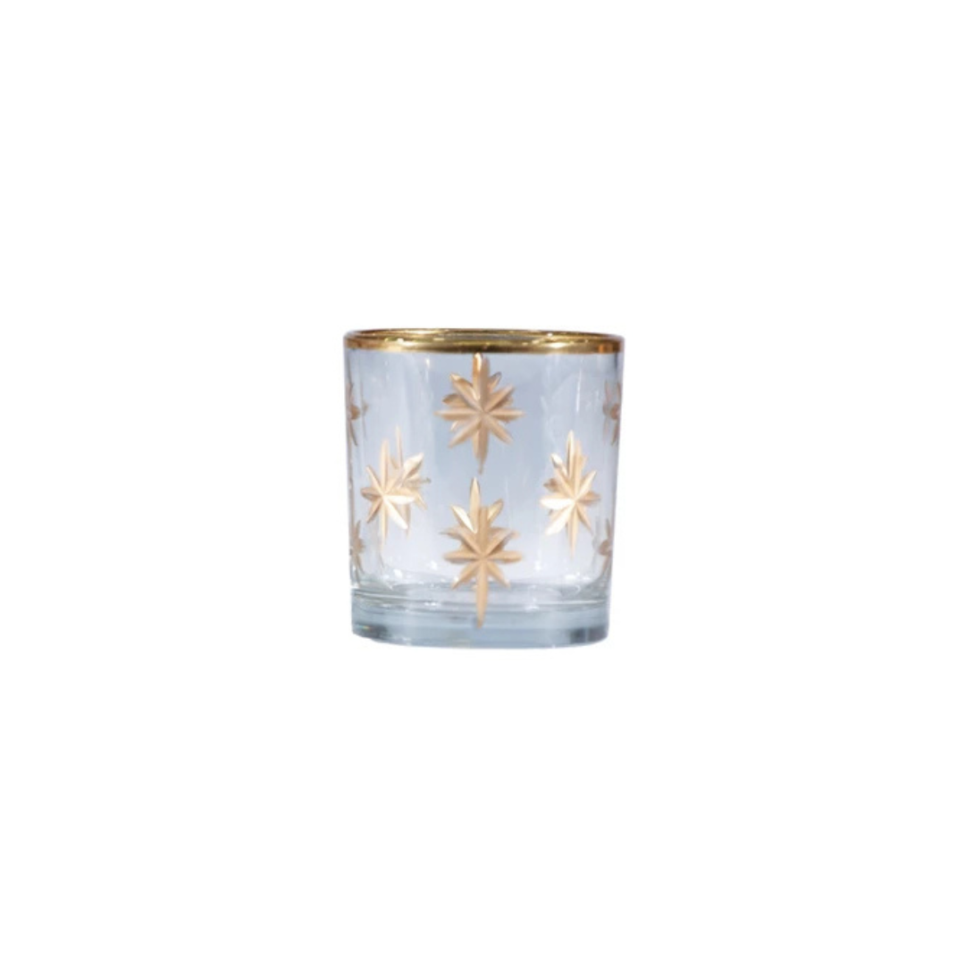 Clear glass candle holder with gold star designs on a white background