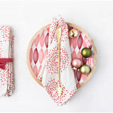 Wooden plate with a red and white patterned napkin, gold fork, and colorful ornaments on a white background.
