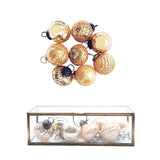 Decorative glass ornaments in a clear box on a white background