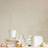 White ceramic cups and decorative items on a neutral background