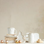 White ceramic cups and decorative items on a neutral background