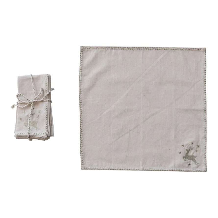 Set of linen placemats with embroidered deer design on a white background