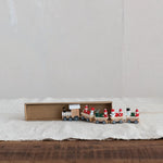 Wooden toy train set with Santa Claus figures on a white surface
