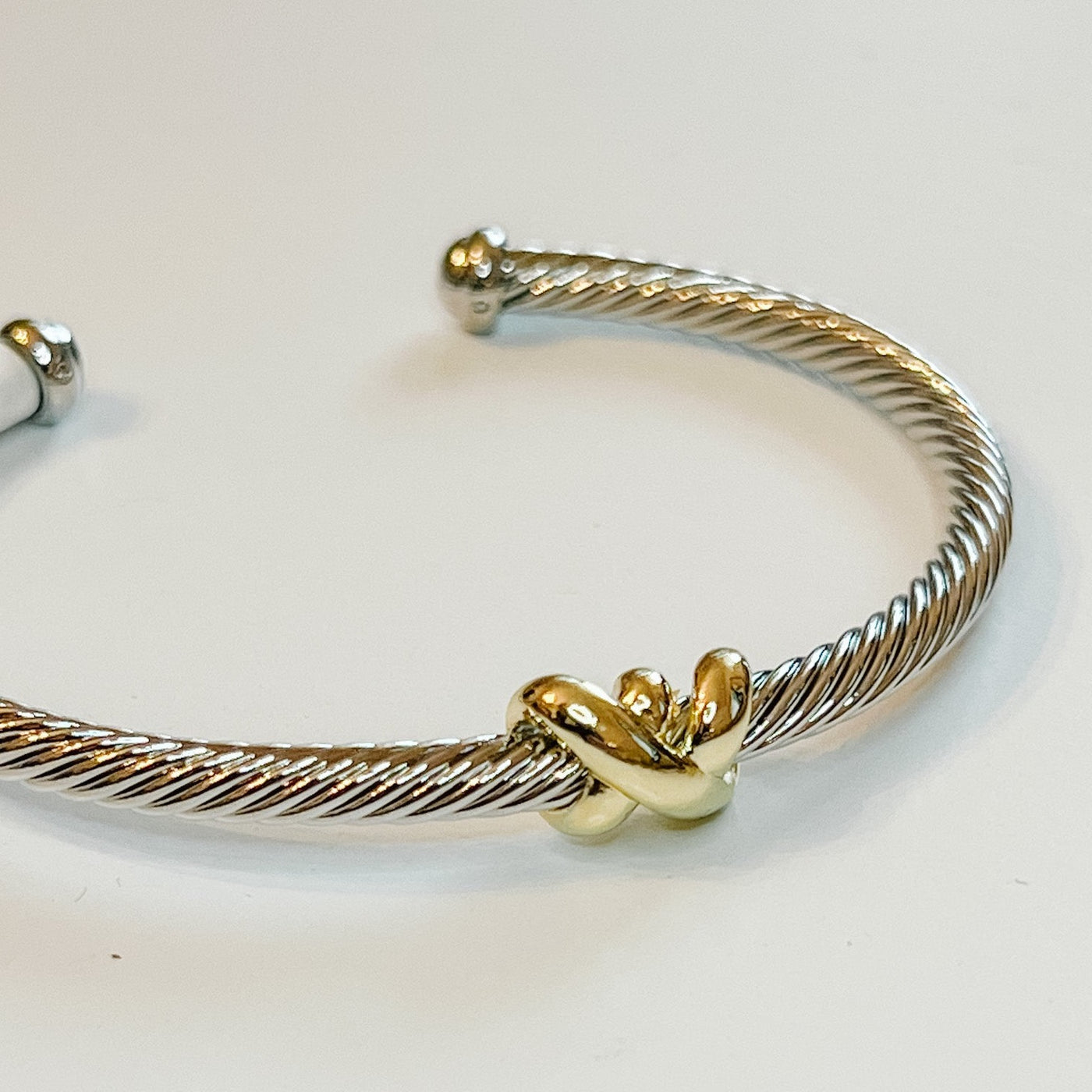 Ashton Bracelet offers smart style with an elegant twist. Crafted with a twisted cable cuff and two tone design, its signature roped gold X adds a distinctive finishing touch.