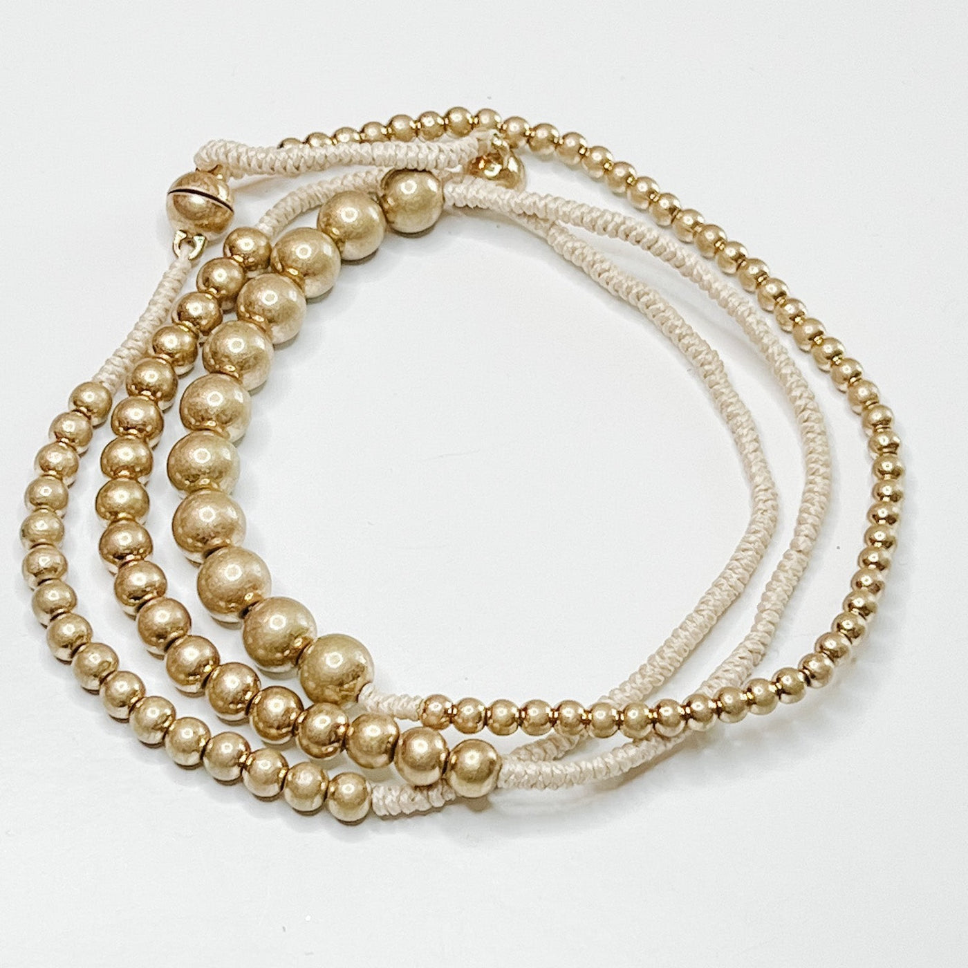 neutral rope and gold ball strand bracelet. Magnetic clasp