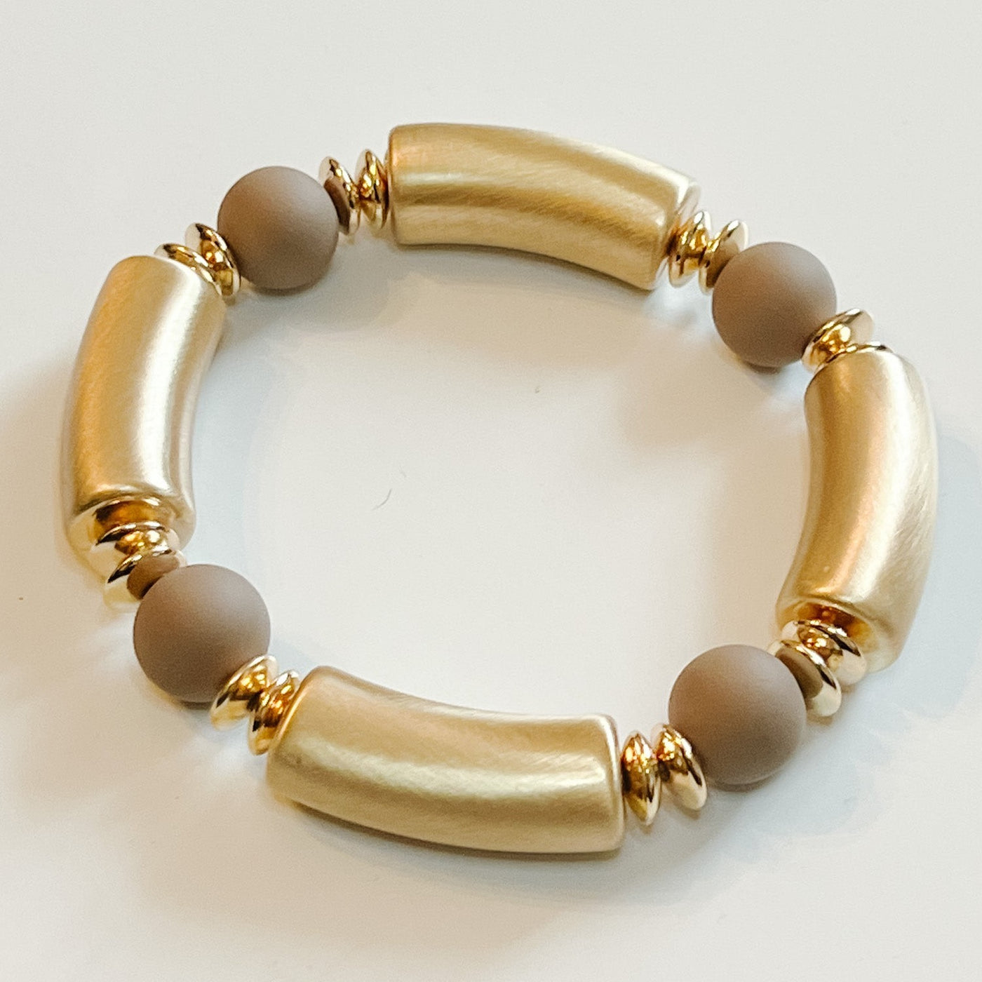 acrylic tubular beaded bracelet with four circular brown and four oval gold beads. 