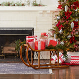 Christmas scene with a decorated tree, presents, and a wooden sled in front of a fireplace.